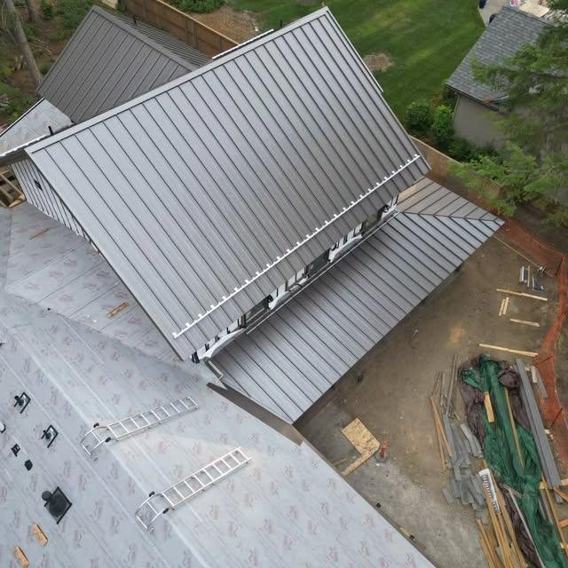Drone view of a standing seam metal roof partway through installation